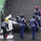 Lewis Hamilton, al lado de su Mercedes siniestrado.