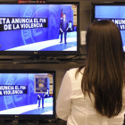 Una mujer observa en las televisiones el anuncio del fin de la violencia el año pasado.