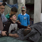 Un niño sirio es consolado mientras llora junto al cuerpo de su hermano pequeño que murió en el ataque aéreo del régimen de Bashar al Asad al hospital de Al Quds.