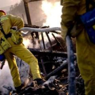 Varios bomberos de Los Ángeles atienden una de las zonas incendiadas