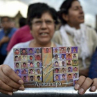 Una mujer muestra la foto de los estudiantes de Ayotzinapa.