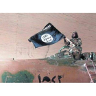 Un militante del Estado islámico ondea una bandera del califato en Raqqa (Siria).
