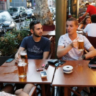 Unos turistas consumiendo jarras de cerveza en el centro de Barcelona.