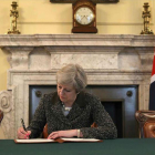 La primera ministra británica, Theresa May, firma la carta con la que arranca el 'brexit'.