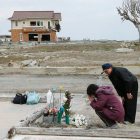 Una pareja reza por su hija, que falleció por el tsunami. MAYAMA