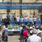 Los niños de San Ildefonso muestran el número agraciado en el sorteo. FERNANDO OTERO
