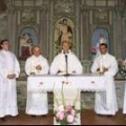 El obispo de Astorga, rodeado de sacerdotes en una imagen de archivo en la iglesia de La Portela