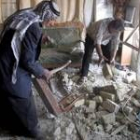 Dos iraquíes miran los daños de un ataque con mortero en Al Sadr