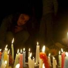 Una niña enciende una vela durante una vigilia en memoria de las víctimas de los atentados
