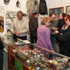 Un grupo de visitantes observa los anzuelos que se exponían en uno de los puestos de la feria.