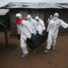 Un equipo médico carga con un cadáver afectado por el ébola en Liberia.