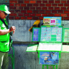 Un vendecor de la Once, junto a su puesto de venta de productos de juegos en León.
