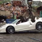 El Ferrari 458 Spider siendo destrozado por una grúa en un desguace.