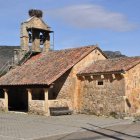 La iglesia de Candanedo de Boñar. A la derecha, el ídolo de la Edad del Bronce que está incrustado en la fachada sur. DAVID GUSTAVO LÓPEZ