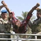 Dos miembros de las Fuerzas de Seguridad iraquíes evacúan a una de las víctimas