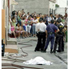 Policías y vecinos, junto al cadáver de la víctima.