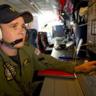 Un oficial de la fuerza aérea australiana a bordo del avión Orion inspecciona la zona donde se han hallado los supuestos restos del avión Malaysia Airlines.