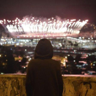 Un niño observa desde el Morro da Mangueira los fuegos artificiales de Maracaná durante la ceremonia de clausura de los Juegos, este domingo.