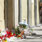 Una mujer observa las flores depositadas ante el instituto Joan Fuster de Barcelona.