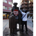Un activista amordaza la estatua de la plaza de las Cortes.