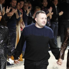 El diseñador británico Kim Jones  flanqueado por las modelos Naomi Campbell  y Kate Moss, saluda al público en su último desfile para la firma Louis Vuitton.