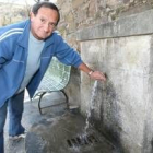 Un vecino de Lombillo comprueba el chorro de una de las fuentes de la localidad