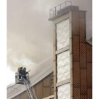 Dos bomberos intentando sofocar el incendio en la Filarmónica
