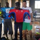 El entrenador de la Peña A cadete, Borja García, entrega el material deportivo peñista en Uganda. DL