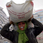 Una mujer palestina recibe un saco de comida del programa de alimentos. MOHAMMED SABER