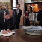 Herrera firma en el libro de honor de la embajada de España en la recepción que le ofreció el embaja