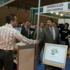 Ángel Penas, saludando ayer al personal de uno de los stands de la feria