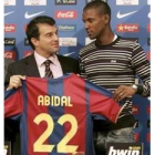 El defensa francés Eric Abidal (d) sostiene una camiseta del Barcelona