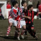 El jugador visitante Óscar es vigilado estrechamente por la defensa del Puente Castro
