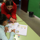 Una niña recibe clases de apoyo escolar de voluntarios de Cruz Roja.