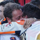 Emilio Alzamora, visiblemente emocionado, abraza y felicita a su pupilo, Marc Márquez, tras la conquista de su sexto título mundial de motociclismo en Valencia.