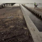 Trabajadores limpian la playa de petróleo y alquitrán, en Waveland, Mississippi.