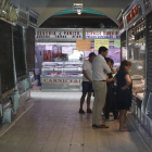 Clientes ayer en uno de los apenas 21 puestos que quedan abiertos en el mercado. MARCIANO PÉREZ