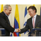 Santos (derecha) estrecha la mano del primer ministro israelí durante una conferencia de prensa conjunta, este martes en Jerusalén.