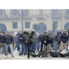 Un manifestante lanza una piedra en la protesta en el centro de Turín, este lunes.