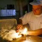 Un panadero italiano amasa alumbrado por una vela