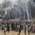 Manifestantes palestinos huyen de los gases lacrimógenos lanzados por los soldados israelís.