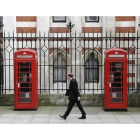 Un peaton anda ante varias de las icónicas cabinas rojas de British Telecom, en Londres.