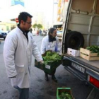 Dos voluntarios del Banco de Alimentos cargando la verdura en el furgón