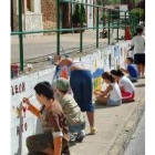 Los niños de Villabalter pintando un muro de la localidad