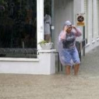 Una mujer intenta atravesar una de las calles inundadas de Salou (Tarragona)