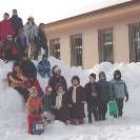 Los niños disfrutan con juegos de la copiosa nieve en el patio del colegio de Riaño