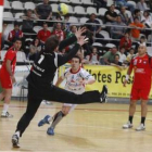 El jugador croata del Ademar Buntic intenta el lanzamiento a portería ante la oposición de Masach y