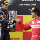 Fernando Alonso, de la escudería Ferrari, estrecha la mano del alemán Sebastian Vettel, en el podio.