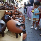 Un joven cliente sopesa gasto y ahorro ante las huchas.