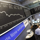 Agentes de Bolsa trabajan ante el gráfico que muestra la caída del DAX 30 de Francfort.